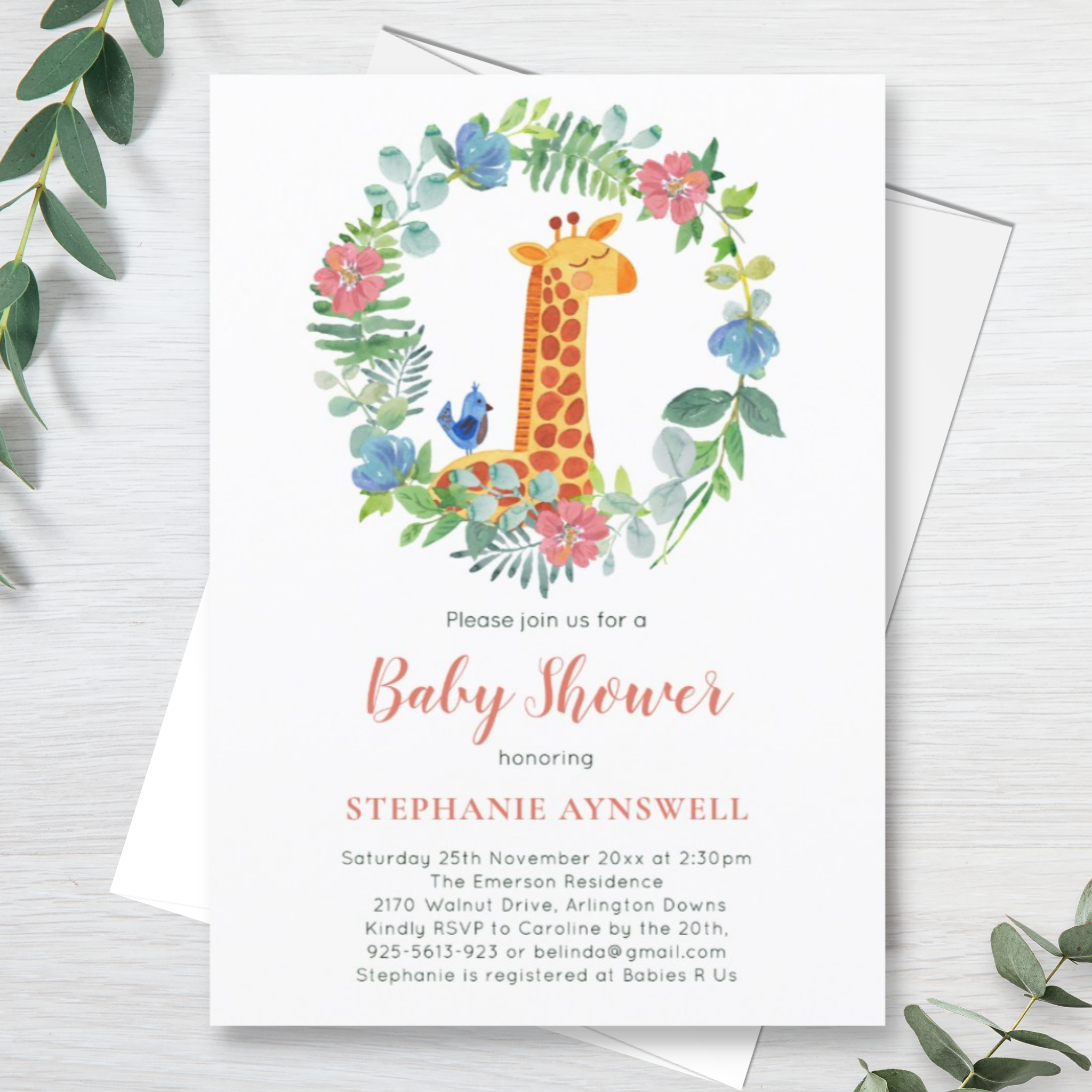 Giraffe baby shower invitation with watercolor giraffe and floral wreath.