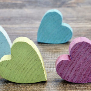 Colorful wooden hearts. Love quotes for wedding anniversary cards.